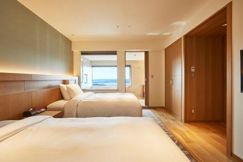 志摩市志摩观光经典酒店的酒店客房设有两张床和窗户。