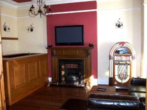 伯恩茅斯金斯利酒店的客厅设有壁炉和平面电视