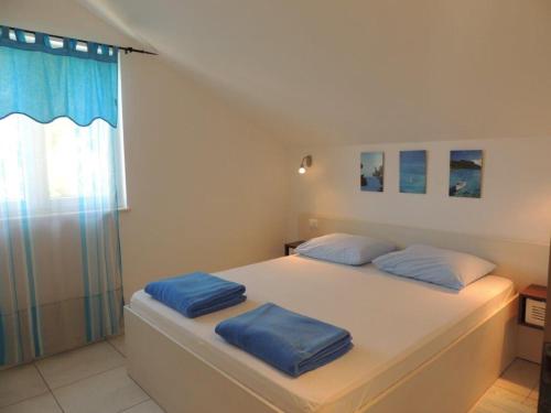 格拉达茨Apartments SVI-MI的一间卧室配有一张带两个蓝色枕头的床
