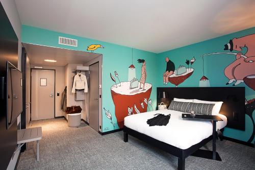 日内瓦日内瓦卡鲁日宜必思尚品酒店的一间卧室配有一张床,墙上挂有绘画作品