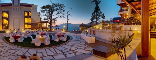 穆索里Royal Orchid Fort Resort Mussoorie的一个带桌椅的场地和一座建筑