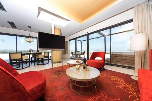 马略卡岛帕尔马GPRO瓦尔帕莱索宫温泉酒店的客厅配有红色椅子和电视