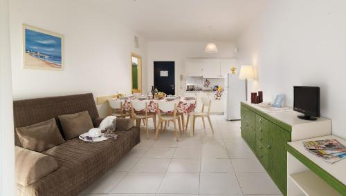 Ca LinoIsaresidence Holiday Resort的客厅以及带沙发和桌子的厨房。