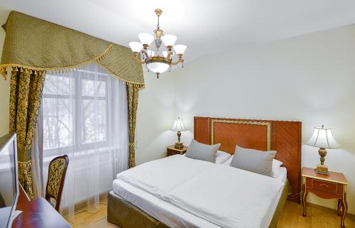 玛丽亚温泉罗马撒酒店的一间卧室配有一张带吊灯和窗户的床。