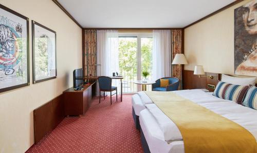 慕尼黑Living Hotel Prinzessin Elisabeth的酒店客房设有一张大床和一张书桌。