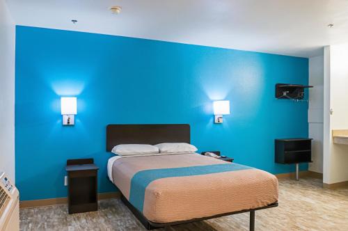 贝圣路易斯Motel 6-Bay Saint Louis, MS的一间卧室设有蓝色的墙壁和一张床