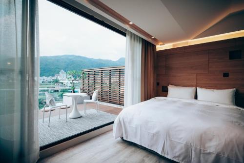 礁溪Onsense villa的一间卧室设有一张床和一个大窗户
