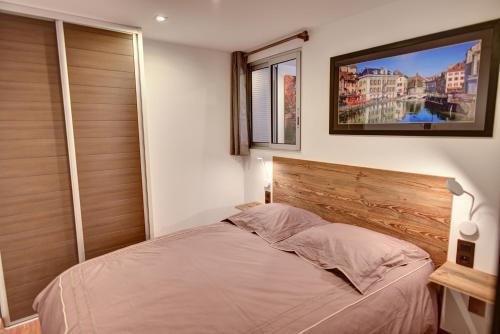 安锡L'atout charme的一间卧室配有一张带木制床头板的床