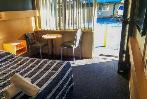 温莎温莎汽车旅馆的配有一张床和一张桌子及椅子的房间