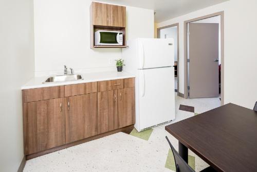 温尼伯UWinnipeg Downtown Hostel的厨房配有水槽和白色冰箱