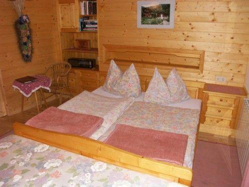 兰格尔斯道夫Ferien-am-Bauernhof-Wohnung-2的木制客房内的一间卧室,配有一张床