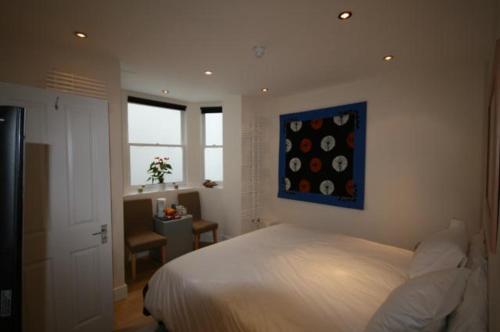 伦敦格罗弗69住宿加早餐旅馆的卧室配有一张床,墙上挂有绘画作品