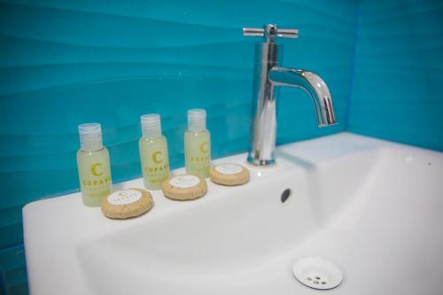 马尔多纳多港Copasu Hotel的浴室水槽配有4瓶肥皂和饼干