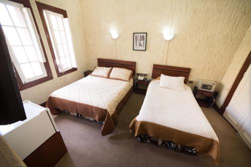 圣地亚哥Si Hotel的一间卧室设有两张床和两个窗户。