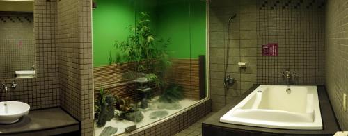 芦竹贝克汉汽车旅馆 的带浴缸的浴室和绿墙(种有植物)