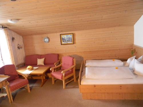 奥伯斯特多夫Landhaus Spielmannsau的一间设有两张床和一张桌子及椅子的房间