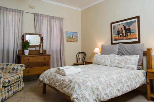 梅尔克博斯特兰Island View f5的一间卧室配有一张床、一把椅子和镜子