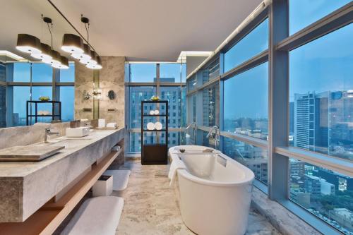 高雄晶英国际行馆 的一间带两个盥洗盆和浴缸的浴室以及窗户。