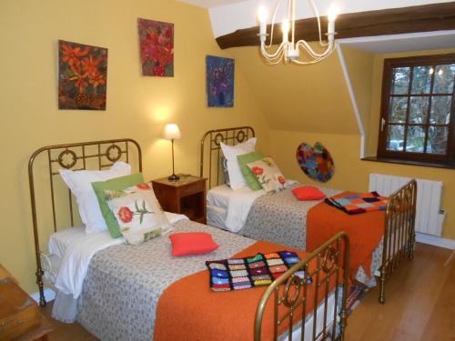 Pontlevoy博尔德农场住宿加早餐旅馆的一间卧室配有两张床和吊灯。
