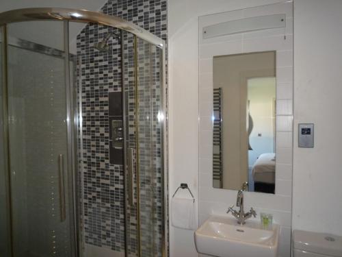 卡斯尔马特Castlemartyr Holiday Mews 3 bed的一间带水槽、淋浴和镜子的浴室