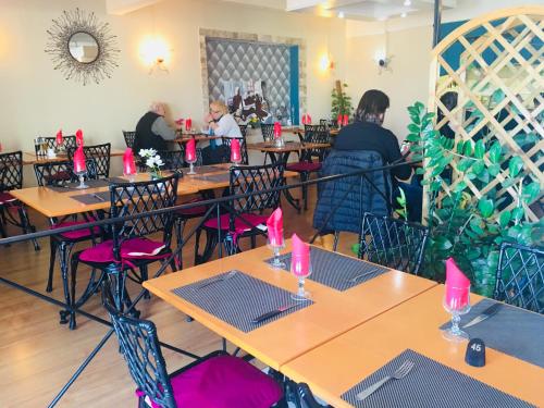 巴斯蒂亚桑浦日罗酒店的餐厅设有桌椅,并备有粉红色蜡烛