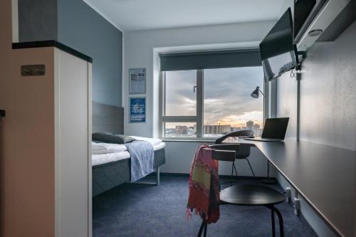 哥本哈根卡宾公寓式酒店的一间卧室配有一张床和一张带笔记本电脑的书桌