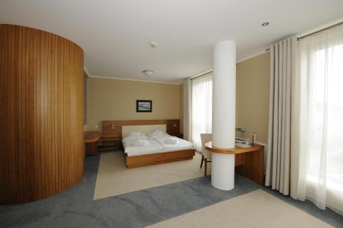 Kravaře布里阿雷纳酒店的配有一张床、一张桌子和一张桌子的酒店客房