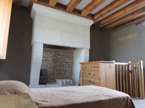 Mareuil-sur-CherEscapade的一间卧室配有一张床和一个砖砌壁炉