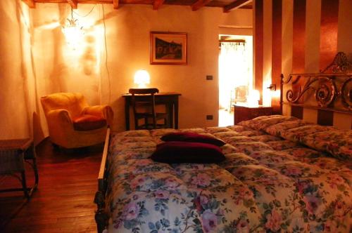 Portula奥罗二伯塔农庄公寓的一间卧室配有一张大床和一把椅子