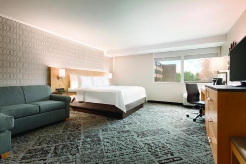 夏洛特夏洛特机场雷迪森酒店的酒店客房,配有床和沙发
