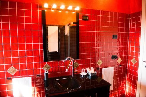 MalgessoTenuta La Vigna的红色瓷砖浴室设有水槽和镜子