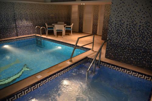 阿可贺巴豪姆因公寓式酒店的酒店客房的大型游泳池配有桌椅