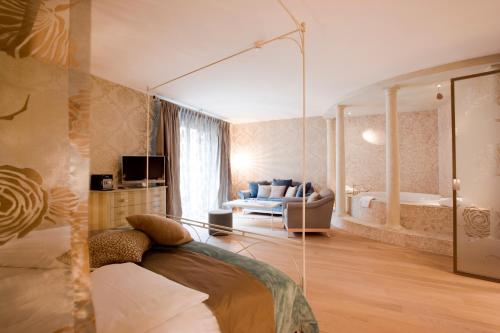 BubendorfBad Bubendorf Design & Lifestyle Hotel的卧室配有床和浴缸