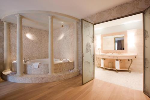 BubendorfBad Bubendorf Design & Lifestyle Hotel的带浴缸和盥洗盆的大浴室