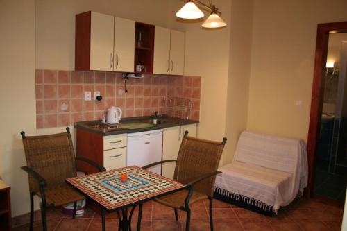 帕廷斯Villa Patio的厨房配有桌子和两把椅子、一张桌子和一张桌子。