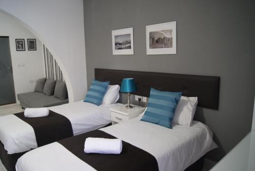 圣保罗湾城Buccaneers Boutique Guest House的酒店客房,设有两张床和一张沙发