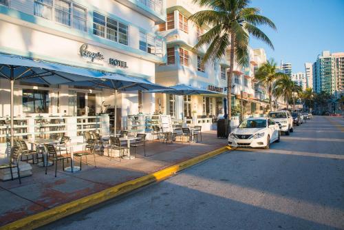 迈阿密海滩企鹅酒店的一条带桌椅的街道和一座建筑