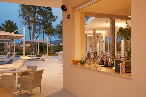 圣多米尼卡TUI BLUE Tropea的一个带桌椅的庭院和一间酒吧