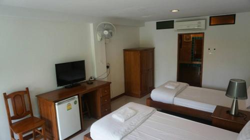 彭世洛Garden Corner Resort & Hotel的一间卧室设有两张床、一台电视和一把椅子