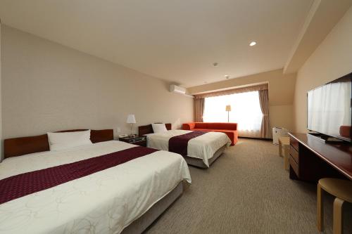 草津町21号酒店的酒店客房设有两张床和一台平面电视。