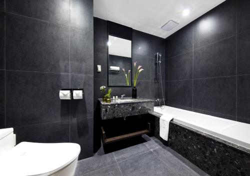 龙仁市龙仁市华美达酒店的一间带水槽、浴缸和卫生间的浴室