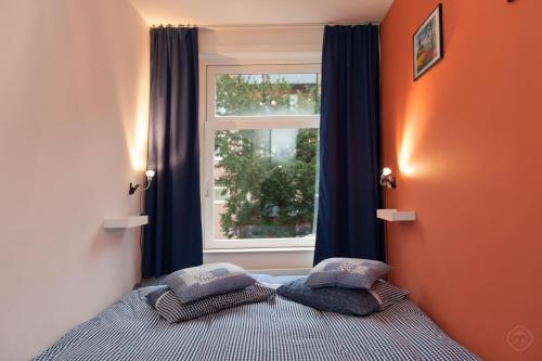 阿姆斯特丹B&B West City Amsterdam的卧室配有一张带枕头的床,位于窗户前