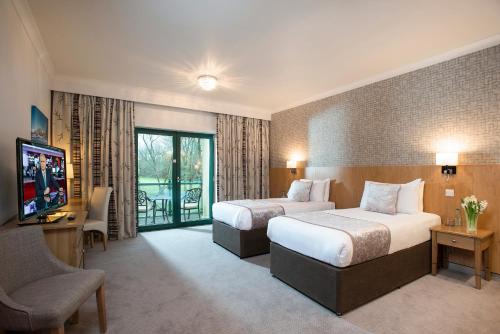 翰索经典英国溪谷酒店度假村的酒店客房设有两张床和电视。