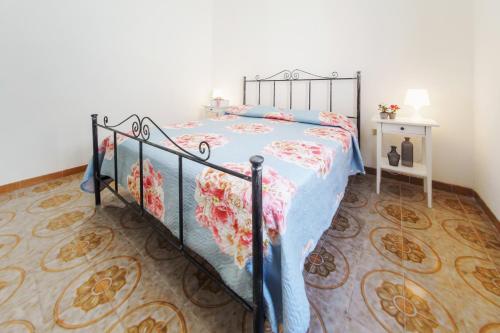 托雷奇安卡Villetta Martino Guest House的一间卧室配有一张带花卉床罩的床