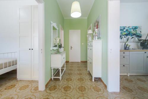 托雷奇安卡Villetta Martino Guest House的一间卧室设有绿色的墙壁、白色的橱柜和梳妆台。