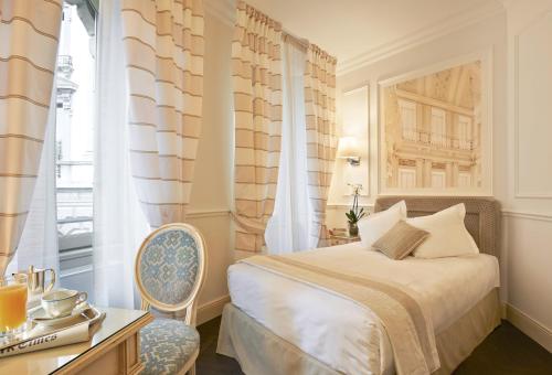 科莫艾尔伯格泰尔密努斯酒店的卧室配有床、椅子和窗户。