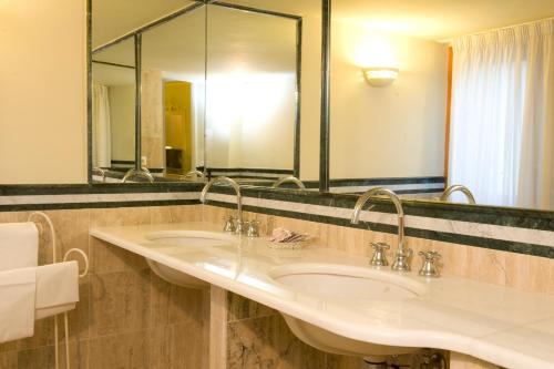 格罗塔费拉塔维拉费拉塔公园酒店的一间带两个盥洗盆和大镜子的浴室