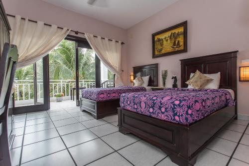 美奈格雷斯精品度假村酒店的一间带两张床的卧室和一个阳台