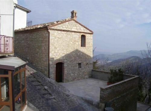 MontemitroB&B Casa Letizia的一座小砖砌建筑,顶上有一扇小门