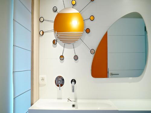 列日Gîte Au26 côté jardin-côté cour的浴室的墙壁上配有灯和水槽